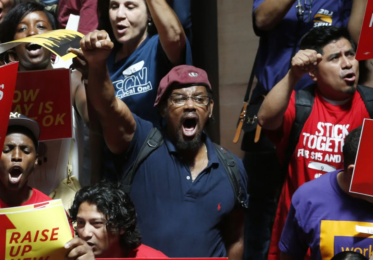 Workers rally for an increase in the minimum wage at the Capitol in Albany, N.Y., on June 17, 2014. Several hundred fast-food workers and other low-wage employees from around New York gathered to pressure lawmakers to raise the minimum wage from $8 to $10.10 an hour and let local cities raise it even higher. (AP Photo/Mike Groll)