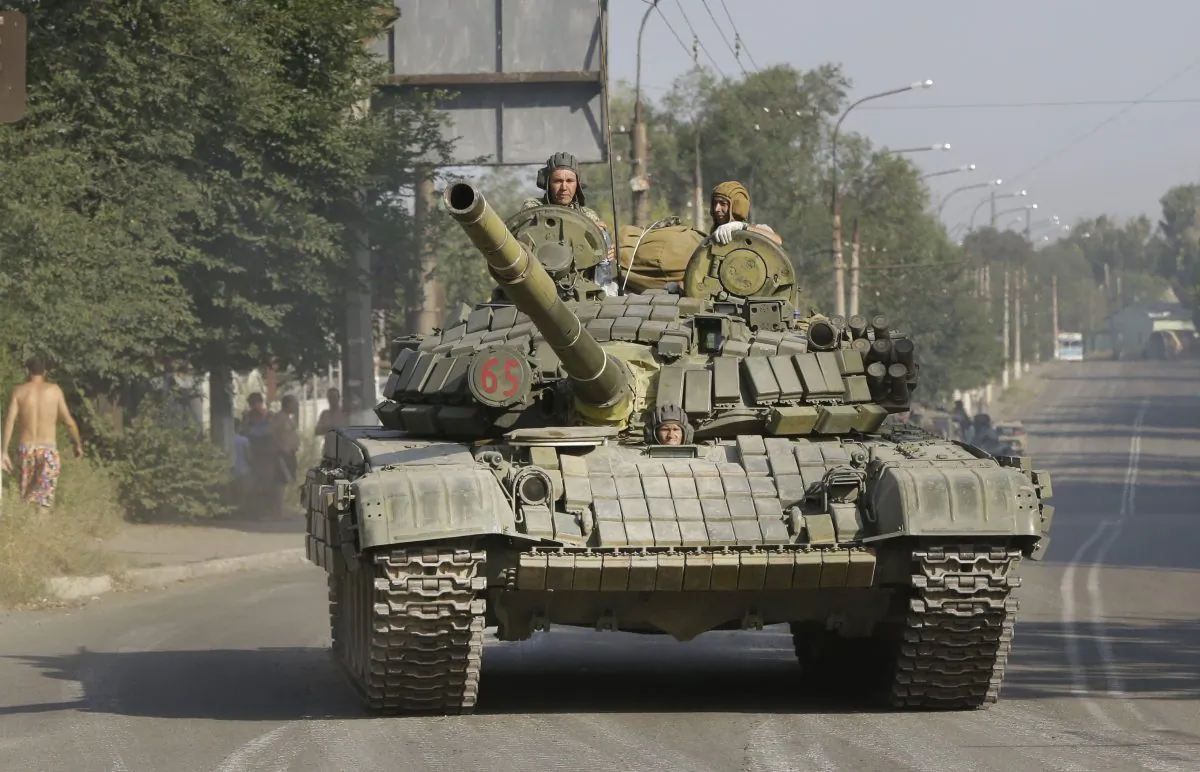 Pro-Russia rebels ride on a tank in the town of Krasnodon, eastern Ukraine, Aug. 17, 2014. On Thursday the presence of invading Russian forces inside Ukraine was confirmed. (AP Photo/Sergei Grits)