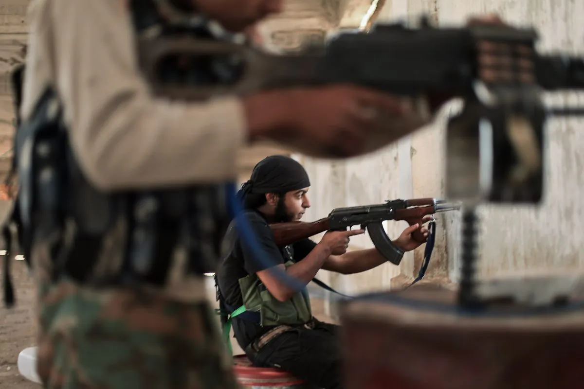 Rebel fighters from the Islamic Front, Syria's largest rebel coalition, hold a position on July 13, 2014, during clashes with militants of the Islamic State (IS). (Ahmed Deeb/Getty Images)