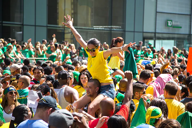 People dressed in Brazil's colors cheer as José Daniel Camillo takes the stage at the 30th anniversary of Brazilian Day New York celebration on Aug. 31, 2014. (Benjamin Chasteen/Epoch Times)