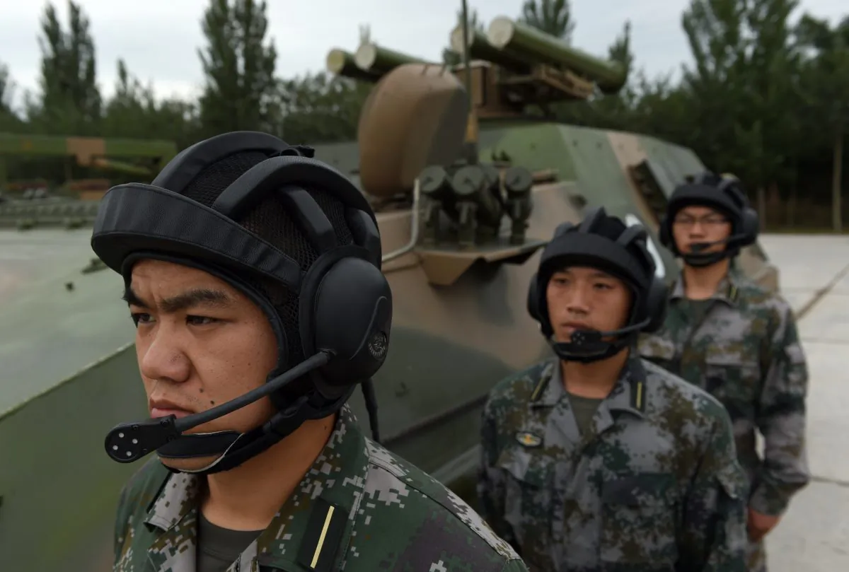 Chinese People's Liberation Army cadets wait beside a T-89 Anti-tank Missile Launcher at the PLA's Armored Forces Engineering Academy in Beijing on July 22. Xi Jinping, head of the Chinese Communist Party, is calling for a new focus on information warfare. (GREG BAKER/AFP/Getty Images)
