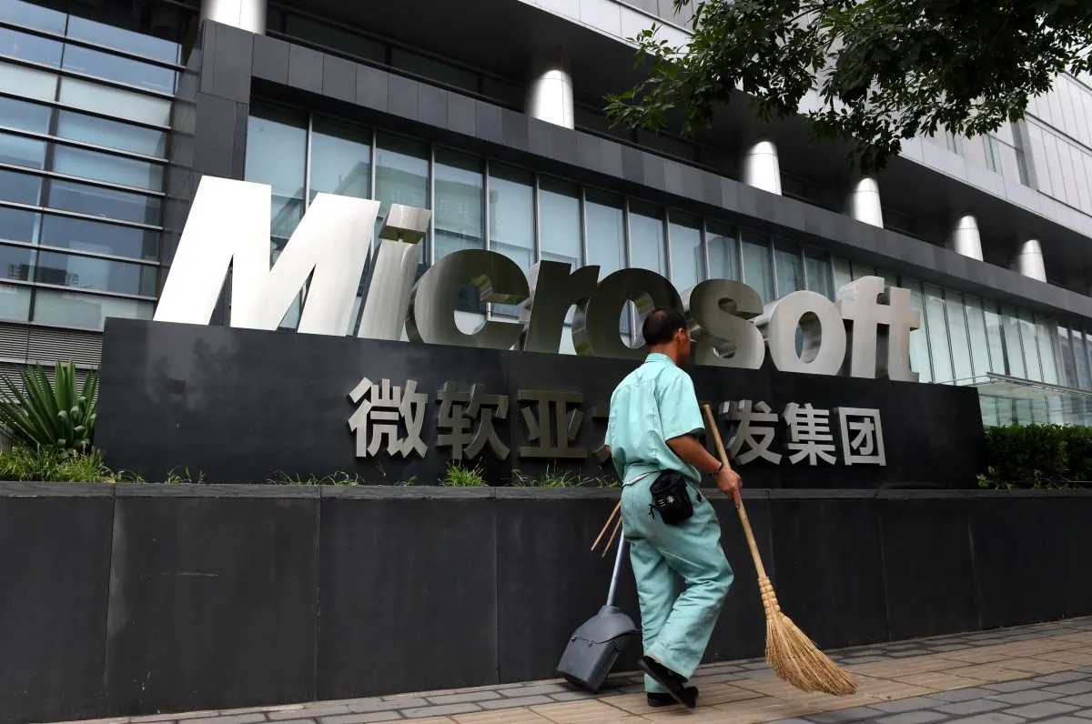 A cleaner walks past a Microsoft sign outside a Microsoft office building in Beijing, on July 31, 2014. (Greg Baker/AFP/Getty Images)
