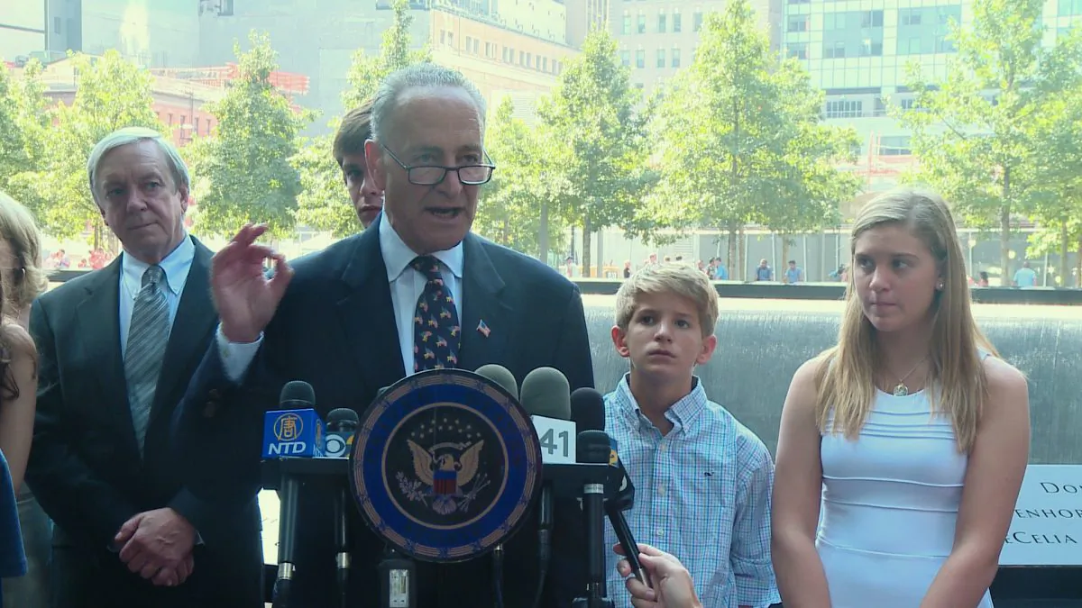 New York Senator Charles E. Schumer and the family of 9/11 victim Tom Strada at 9/11 memorial in Manhattan, N.Y. on Monday, Sept. 1, 2014. Schumer pushed a bill, which allows foreign countries to be sued for funding terrorism. (Henry Yan/NTD Television)