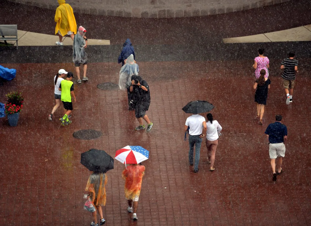People walk to the exits after rain caused a suspension of play during the 2014 U.S. Open tennis at the USTA Billie Jean King National Tennis Center in Queens, on Sunday. (STAN HONDA/AFP/Getty Images)