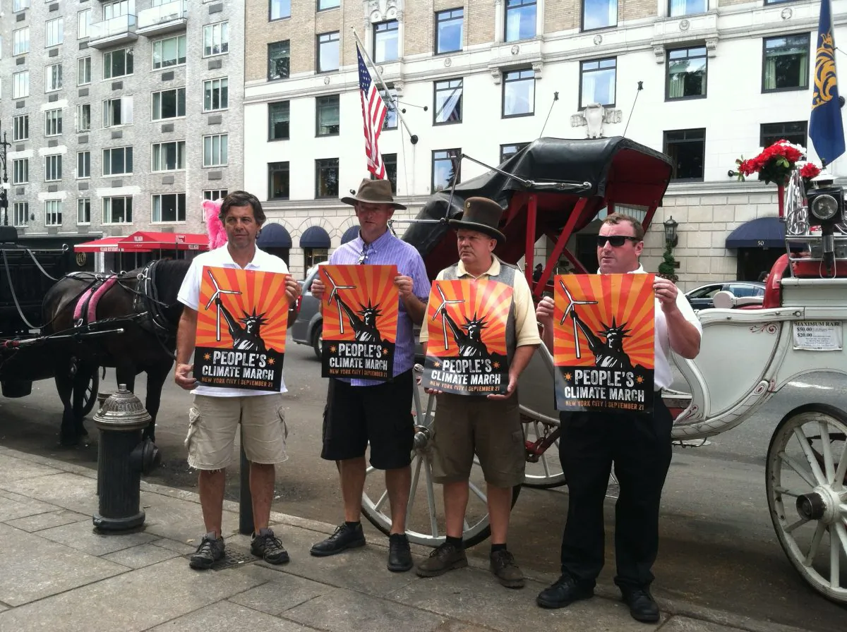 Horse carriage drivers near Central Park hold up posters in support of the People's Climate March, on Sept. 1, 2014. The horse carriage industry announced that they plan to attend the Sept. 21 march that will be the largest organized event to call attention to the negative effects of climate change. (Annie Wu/Epoch Times)