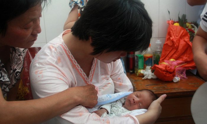 A woman reunites with her newborn baby who was sold by the doctor who delivered him at a hospital in Fuping County, central China's Shanxi province on Aug. 5, 2013. Other cases have been reported across China in recent years. (STR/AFP/Getty Images)