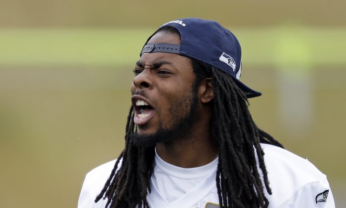 FILE - In this June 12, 2014, file photo, Seattle Seahawks' Richard Sherman yells during an NFL organized team activity football practice in Renton, Wash. Where he’s gone from being largely overlooked coming out of Stanford, to being one of the most polarizing figures in the NFL. There isn’t much of a middle ground with Sherman. He’s either loved for a style that borders on cockiness, or he’s despised for the same reason. (AP Photo/Elaine Thompson, File)