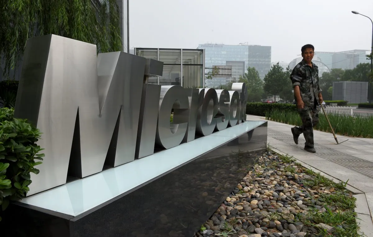 A man walks past a Microsoft sign outside a Microsoft office building in Beijing on July 31. Foreign business in China feel less welcomed, as Microsoft and many other U.S. companies are being targeted in anti-trust probes by Chinese authorities. (Greg Baker/AFP/Getty Images)
