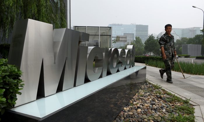 A man walks past a Microsoft sign outside a Microsoft office building in Beijing on July 31. Foreign business in China feel less welcomed, as Microsoft and many other U.S. companies are being targeted in anti-trust probes by Chinese authorities. (GREG BAKER/AFP/Getty Images)