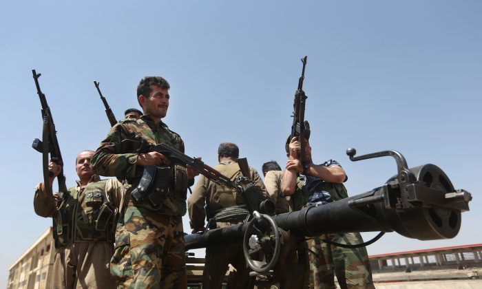 In this Wednesday, June 25, 2014 file photo, Kurdish peshmerga fighters take positions on the front line with militants from the al-Qaida-inspired Islamic State in Iraq and the Levant (ISIL), in Tuz Khormato, 100 kilometers (62 miles) south of the oil rich province of Kirkuk, northern Iraq. (AP Photo/Hussein Malla, File)