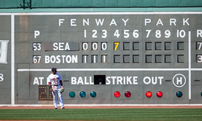 Yoenis Cespedes of the Boston Red Sox looks at the scoreboard and the 7-run inning posted for the Seattle Mariners during the fourth inning at Fenway Park on August 23, 2014 in Boston, Massachusetts. (Rich Gagnon/Getty Images) 