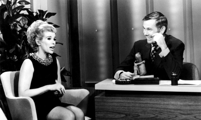 This undated image released by NBC shows comedian Joan Rivers, left, and host Johnny Carson during "The Tonight Show Starring Johnny Carson," in Burbank, Calif. Rivers, the raucous, acid-tongued comedian who crashed the male-dominated realm of late-night talk shows and turned Hollywood red carpets into danger zones for badly dressed celebrities,  died Thursday, Sept. 4, 2014. She was 81. Rivers was hospitalized Aug. 28, after going into cardiac arrest at a doctor's office.  (AP Photo/NBC)