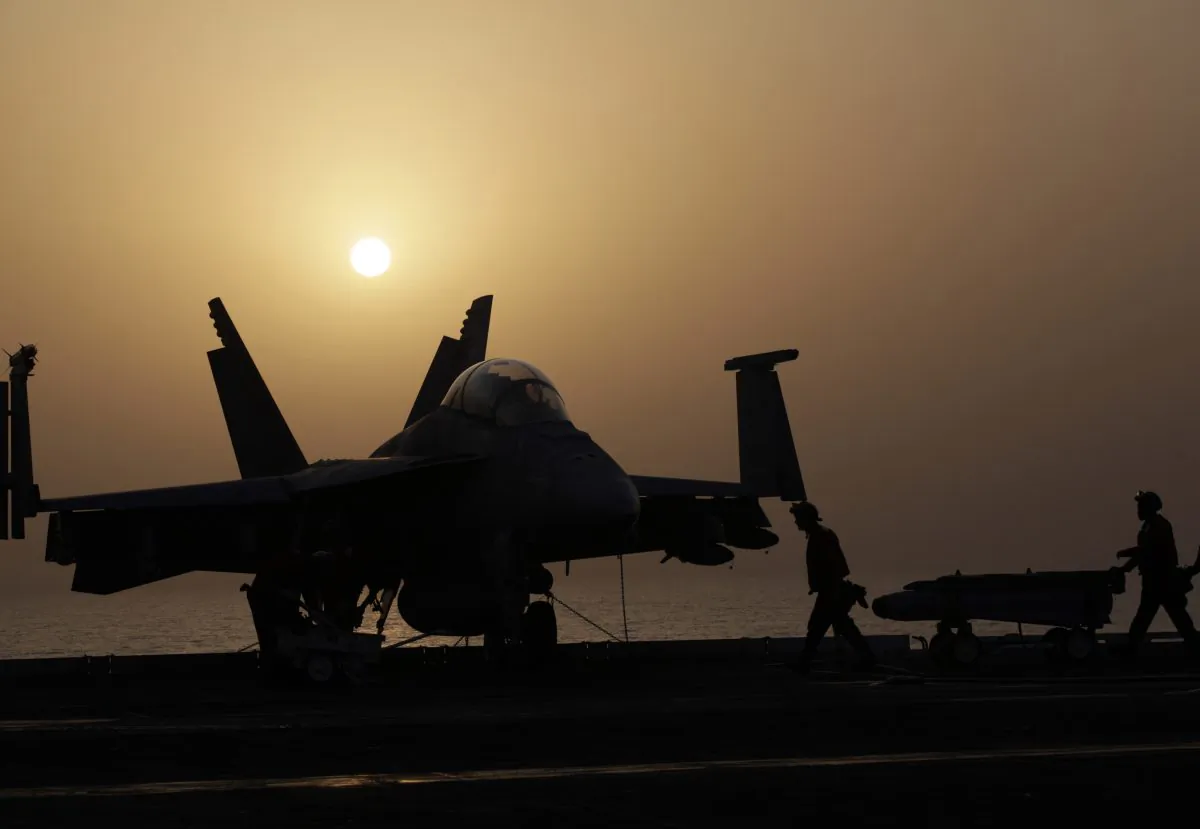 Sailors push missiles on the flight deck of the US Navy aircraft carrier USS George H.W. Bush on Aug. 10, 2014 in the Persian Gulf. Aircraft aboard the George H.W. Bush are flying missions over Iraq after US President Barack Obama authorized airstrikes against Islamic militants and food drops for Iraqis trapped by the fighters. (AP Photo/Hasan Jamali)