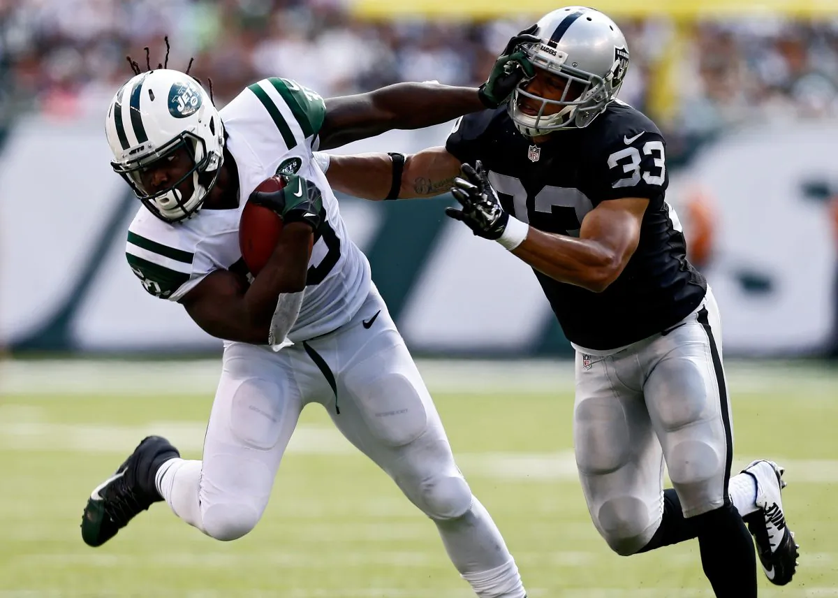 EAST RUTHERFORD, NJ - SEPTEMBER 07: Chris Ivory #33 of the New York Jets stiffarms Tyvon Branch #33 of the Oakland Raiders during the second quarter at MetLife Stadium on September 7, 2014 in East Rutherford, New Jersey. (Photo by Jeff Zelevansky/Getty Images)