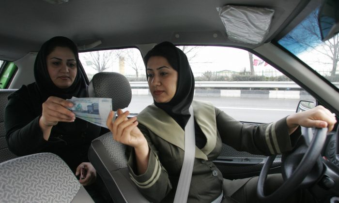 A file photo of an Iranian woman paying a female taxi driver in a women-only cab at the end of her trip in the capital Tehran (Atta Kenare/AFP/Getty Images)