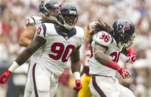 Houston Texans safety D.J. Swearinger (36) celebrates with outside linebacker Jadeveon Clowney (90) after sacking Washington Redskins quarterback Robert Griffin III (10) in the first half of an NFL football game Sunday, Sept. 7, 2014, in Houston. Houston defeated Washington 17-6. (AP Photo/ The Courier, Jason Fochtman)