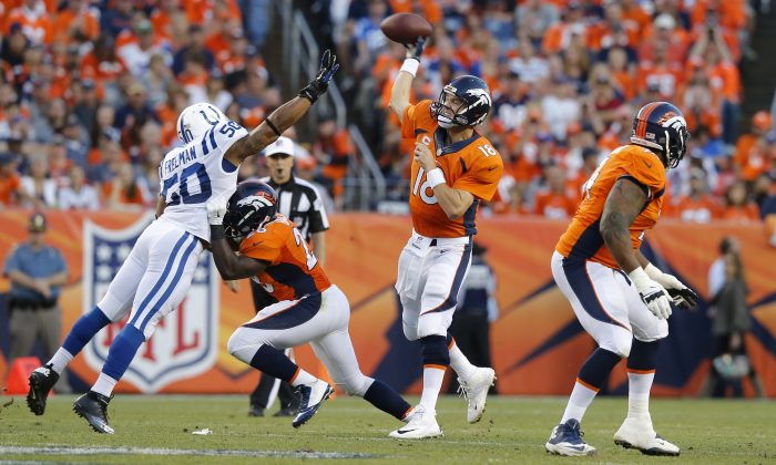 Denver Broncos quarterback Peyton Manning (18) throws under pressure from Indianapolis Colts inside linebacker Jerrell Freeman (50) during the first half of an NFL football game, Sunday, Sept. 7, 2014, in Denver. (AP Photo/Jack Dempsey)