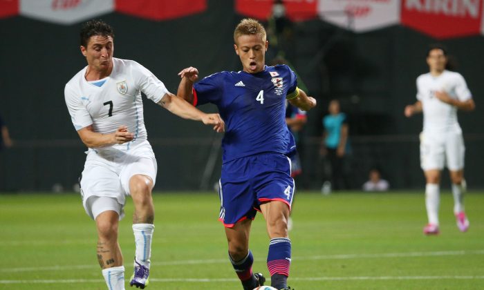 Keisuke Honda (R) of Japan and Cristian Rodriguez (L) of Uruguay compete for the ball during the KIRIN CHALLENGE CUP 2014 international friendly match between Japan and Uruguay at Sapporo Dome on September 5, 2014 in Sapporo, Japan. (Photo by Atsushi Tomura/Getty Images)