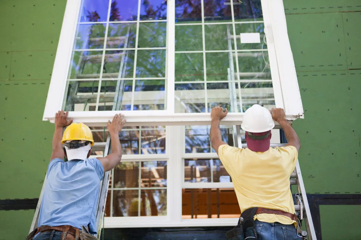 Workmen install a large window in a home. (Huntstock/Thinkstock)