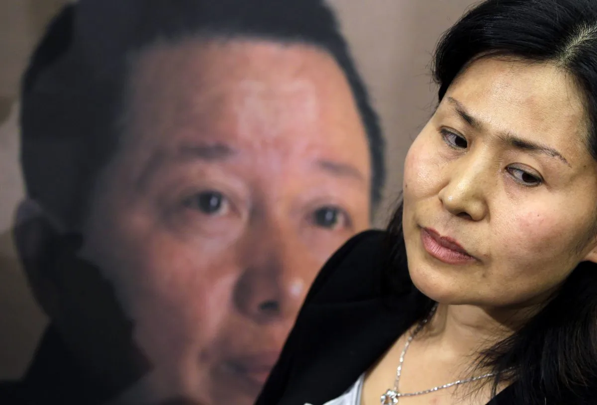 Geng He, wife of disappeared Chinese human rights lawyer Gao Zhisheng, seen on a poster at rear, on Capitol Hill in Washington, Tuesday, Jan. 18, 2011. (AP Photo/Charles Dharapak)