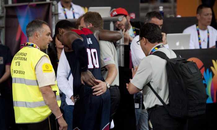 Kyrie Irving of the US, is helped off the court after falling, during the Group C Basketball World Cup match against Ukraine, in Bilbao northern Spain, Thursday, Sept. 4, 2014. The 2014 Basketball World Cup competition take place in various cities in Spain from Aug. 30 through to Sept. 14. (AP Photo/Alvaro Barrientos)