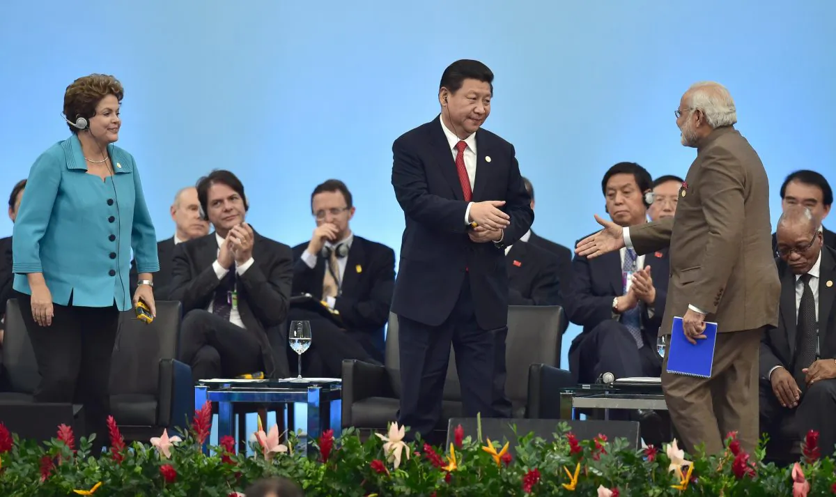 Chinese leader Xi Jinping (C) and India's PM Narendra Modi (R) shake hands at the 6th BRICS summit in Fortaleza, Brazil on July 15, 2014. Xi Jinping is scheduled to make his first visit to India next week. (Nelson Almeida/AFP/Getty Images)
