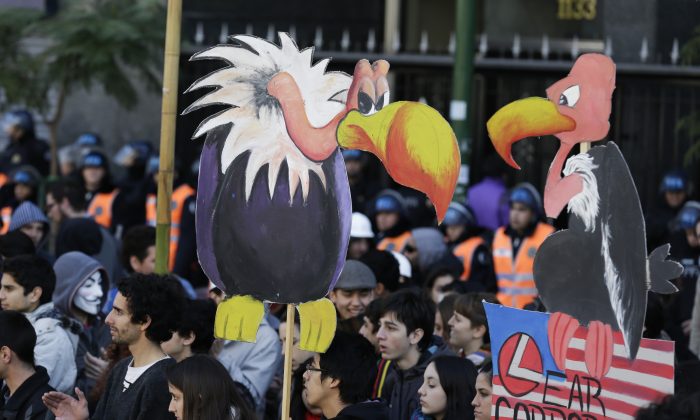 Protesters hold cutouts of vultures during a demonstration in front of the U.S. Chamber of Commerce in Buenos Aires, Argentina, on Aug. 15, 2014. Students gathered to protest against the recent closing of U.S. company R.R. Donnelley & Sons printing plant on the outskirts of the Argentine capital, the layoffs of about 60 workers at the American car parts maker Lear and against the ruling by U.S. Judge Thomas Griesa in favor of a U.S. hedge fund, known locally as "vulture funds." (AP Photo/Victor R. Caivano)