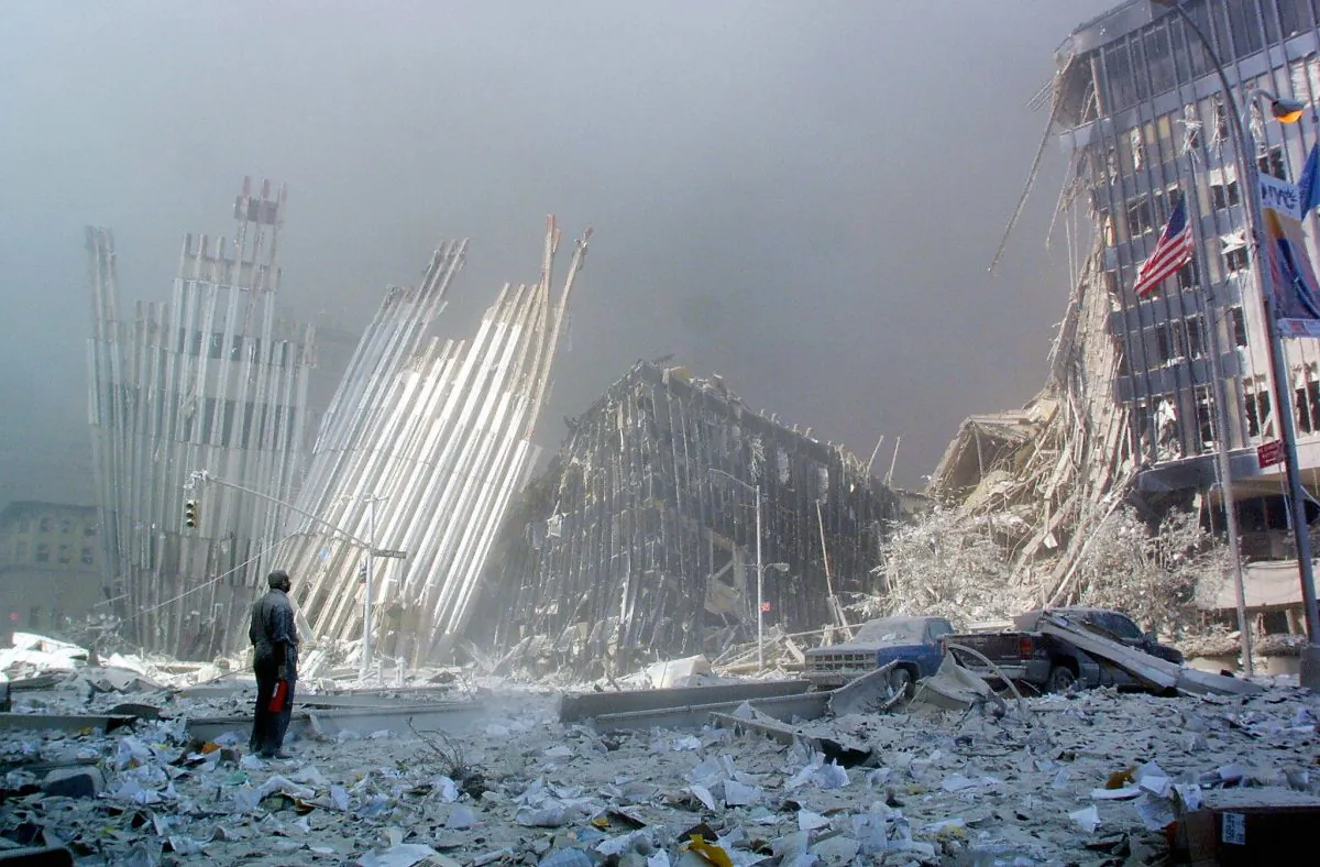 A man standing amid rubble calls out asking if anyone needs help following the collapse of the first World Trade Center tower in New York on Sept. 11 2001. (Doug Kanter/AFP/Getty Images)