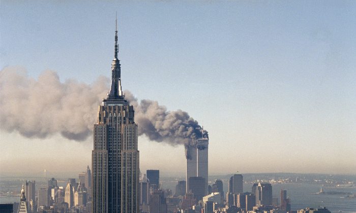 The twin towers of the World Trade Center burn behind the Empire State Building in New York, Sept. 11, 2001. In a horrific sequence of destruction, terrorists crashed two planes into the World Trade Center causing the twin 110-story towers to collapse. (AP Photo/Marty Lederhandler)