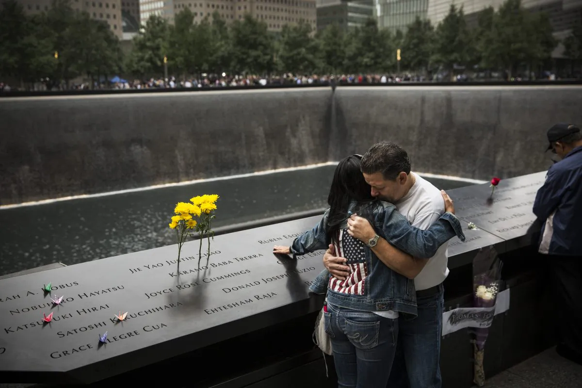 Eileen Esquilin hugs her husband, Joe Irizarry, while mourning the loss of her brother, Ruben Esquilin Jr., during Sept. 11 memorial observances in New York City on Thursday. (Andrew Burton/Getty Images)