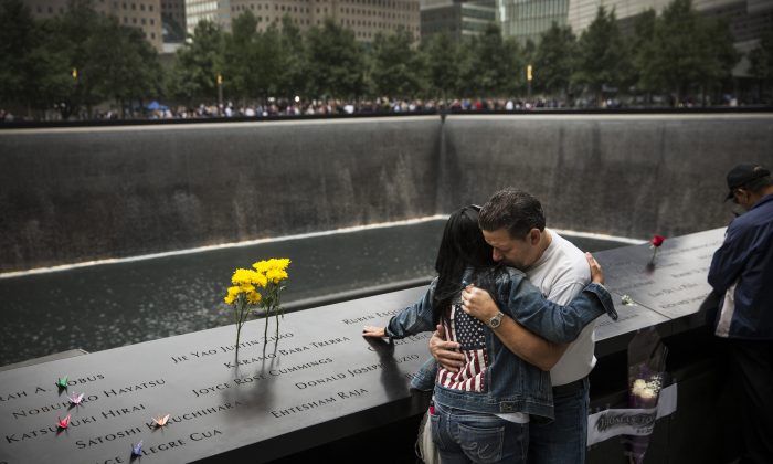 Eileen Esquilin hugs her husband, Joe Irizarry, while mourning the loss of her brother, Ruben Esquilin Jr., during Sept. 11 memorial observances in New York City on Thursday. (Andrew Burton/Getty Images)