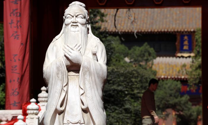 A man walks beside the statue of Confucius at the Confucius Temple in Beijing, China, on Sept. 28, 2010. (Liu Jin/AFP/Getty Images)