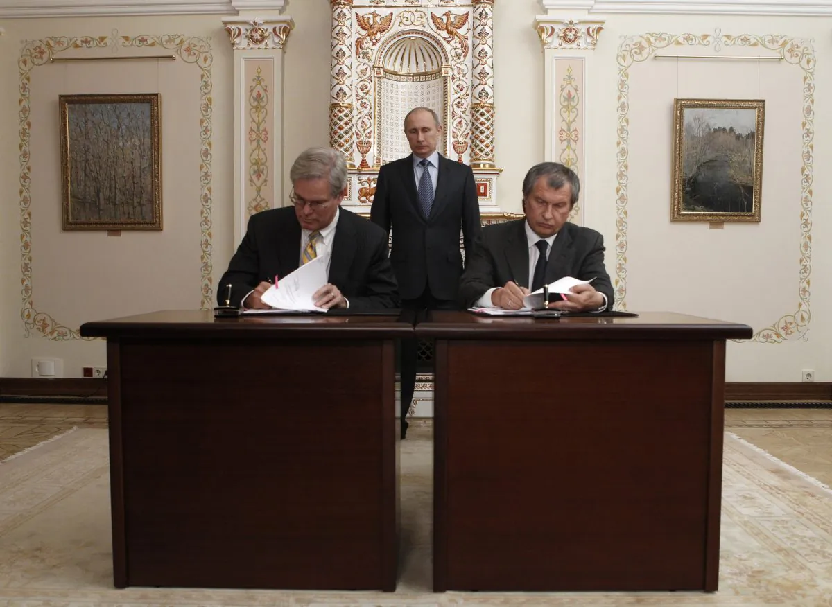 Russian oil giant Rosneft CEO Igor Sechin (R) and President of ExxonMobil Exploration Company Stephen Greenlee, sign documents as Russia's President Vladimir Putin watches at the Novo-Ogaryovo state residence outside Moscow, on Feb. 13, 2013. (Sergei Karpukhin/AFP/Getty Images)