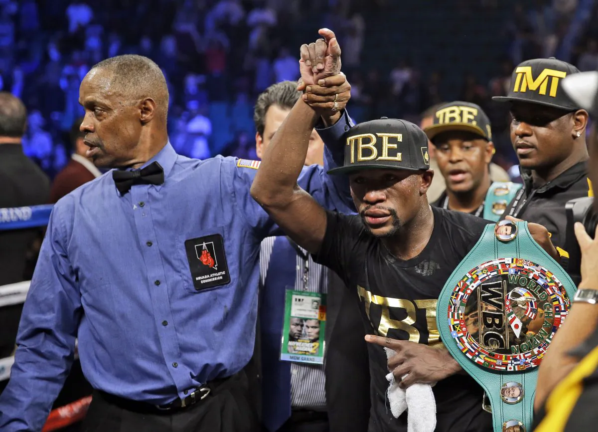 Floyd Mayweather shows off his belts after beating Marcos Maidana during their WBA welterweight and WBC super  welterweight title fight, Saturday, Sept. 13, 2014, in Las Vegas. (AP Photo/John Locher)