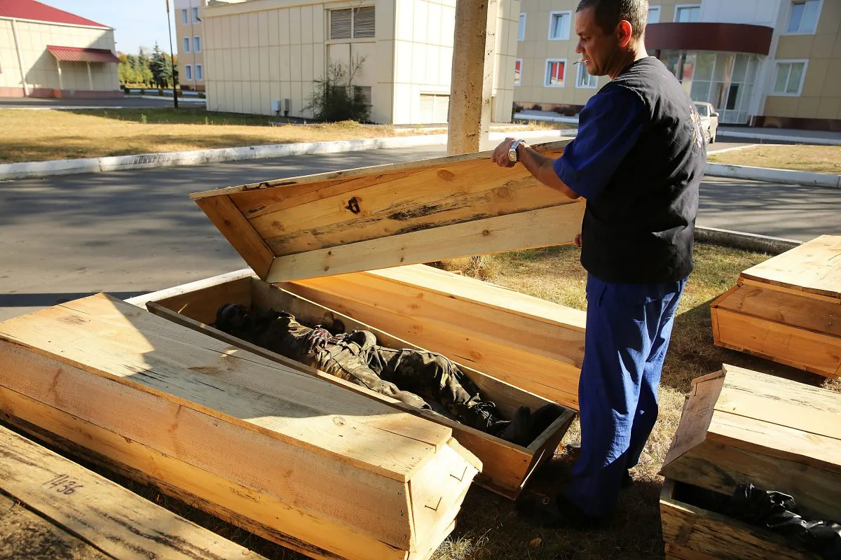 Morgue worker Sergiy Pilipenko inspects the coffins of unclaimed bodies, both civilians and soldiers, outside of the city morgue in Luhansk, Ukraine, on Sept. 14, 2014. Luhansk, a separatist-held city close to the border with Russia, has witnessed some of the heaviest fighting between Russian-backed separatist soldiers and Ukrainian troops. (Spencer Platt/Getty Images)