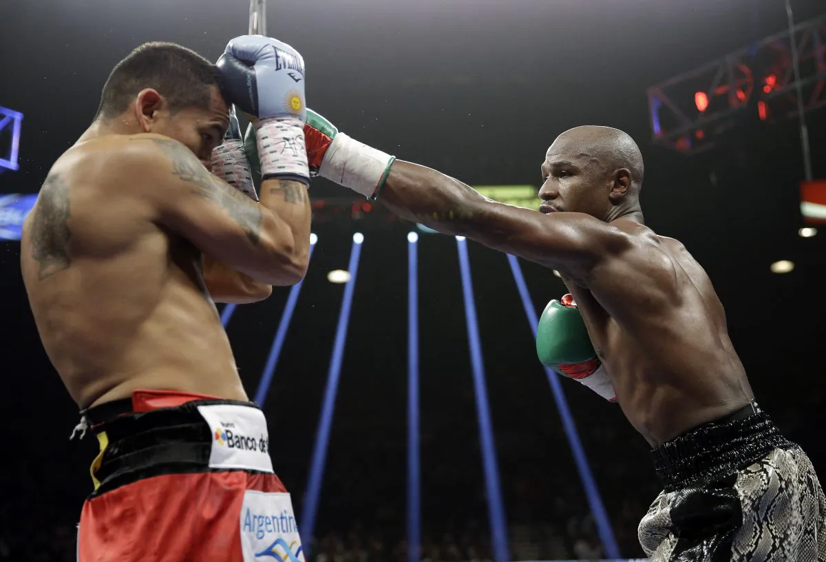 Floyd Mayweather punches Marcos Maidana, left, during their WBA welterweight and WBC super welterweight title fight, Saturday, Sept. 13, 2014, in Las Vegas. (AP Photo/John Locher)