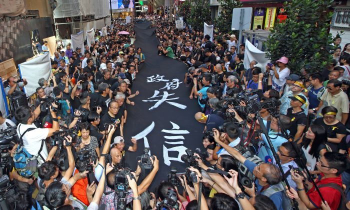 4000 supporters of Hong Kong’s Occupy Central movement participated in the Black Cloth March wearing black shirts and yellow ribbons, and holding 450 meters of black banners, in central Hong Kong on Sept. 14, 2014. (Pan Zaishu/Epoch Times)
