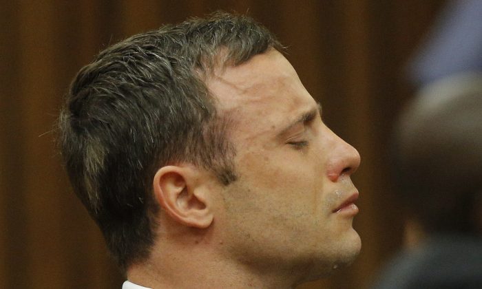 Oscar Pistorius reacts in the dock as Judge Thokozile Masipa delivers her verdict during his murder trial in Pretoria, South Africa, Thursday Sept. 11, 2014. Masipa ruled out a murder conviction for the double-amputee Olympian in the shooting death of his girlfriend, Reeva Steenkamp, but said he was negligent, raising the possibility he'll be convicted of culpable homicide. (AP Photo/Kim Ludbrook, Pool)