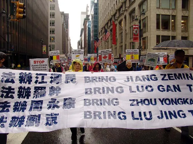 In a parade held in New York City, Falun Gong practitioners carry a banner calling for four Chinese regime officials to be brought to justice for their role in the persecution of the spiritual practice of Falun Gong, on Nov. 20, 2004. As the head of the Chinese regime’s security forces, Zhou played a leading role in driving forward the campaign against Falun Gong. (Minghui.org)