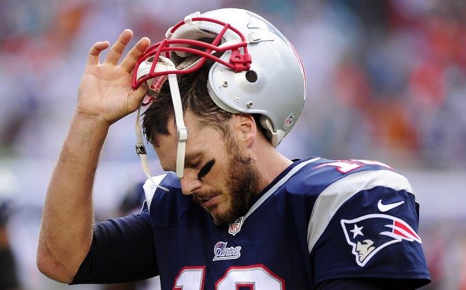 New England Patriots quarterback, Tom Brady, removes his helmet after failing to pick up a first down against the Miami Dolphins late in the fourth quarter Sunday, Sept. 7, 2014 at Sun Life Stadium in Miami Gardens, Fla. . Miami beat New England 33-20. (AP Photo/Naples Daily News, Corey Perrine) FORT MYERS OUT