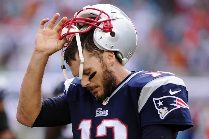 New England Patriots quarterback, Tom Brady, removes his helmet after failing to pick up a first down against the Miami Dolphins late in the fourth quarter Sunday, Sept. 7, 2014 at Sun Life Stadium in Miami Gardens, Fla. . Miami beat New England 33-20. (AP Photo/Naples Daily News, Corey Perrine) FORT MYERS OUT