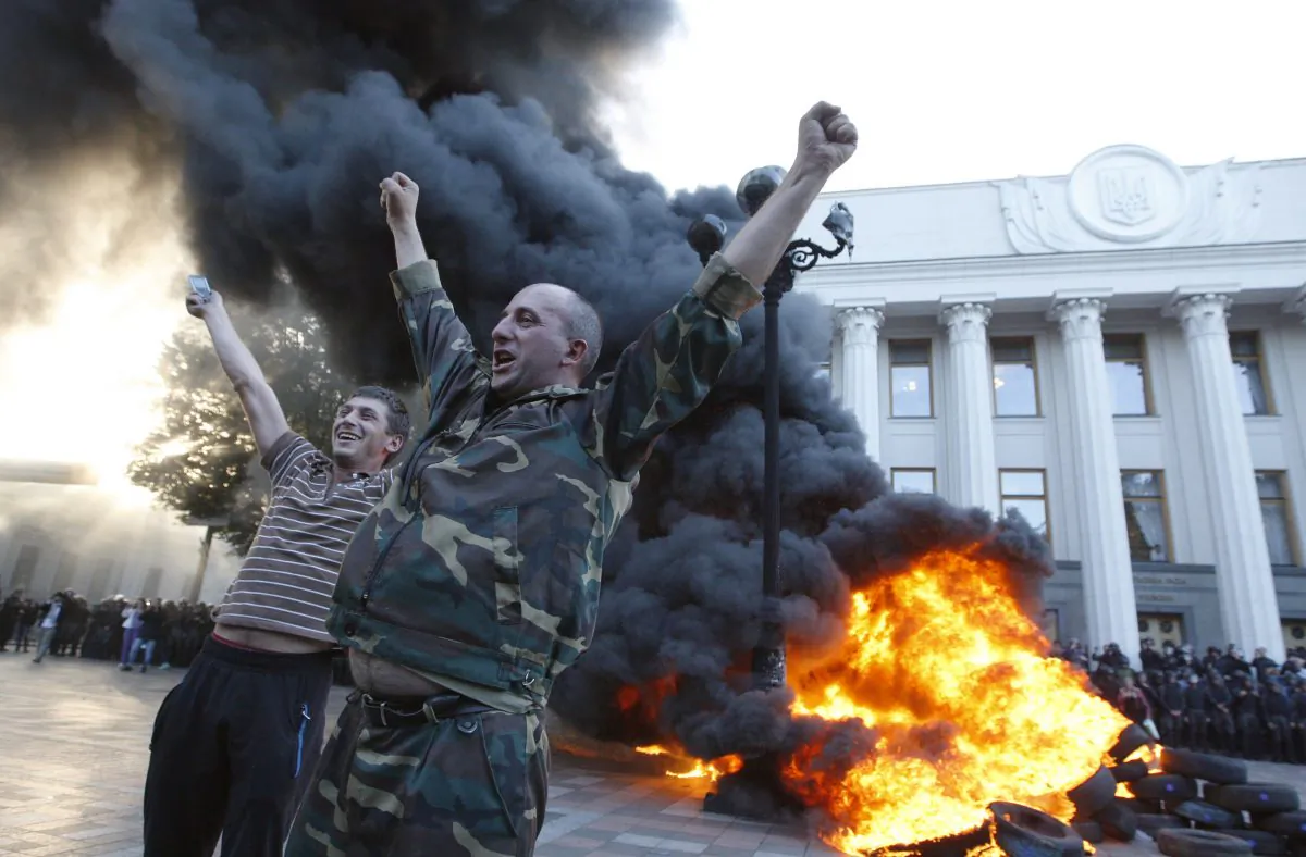 Protesters react as they set tires on fire outside the Ukrainian Parliament on Tuesday. (Yuriy Kirnichny/AFP/Getty Images)