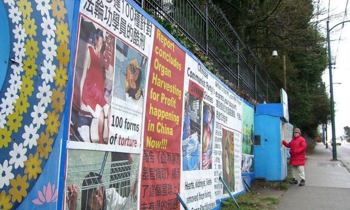 This 2004 file photo shows a Falun Gong adherent standing near the hut and signs erected outside the Vancouver Chinese consulate to protest the brutal treatment of fellow adherents in China. The Vancouver Falun Gong have launched a court challenge to have a street bylaw ruled unconstitutional in the hopes of resuming their round-the-clock vigil outside the consulate. (Epoch Times)
