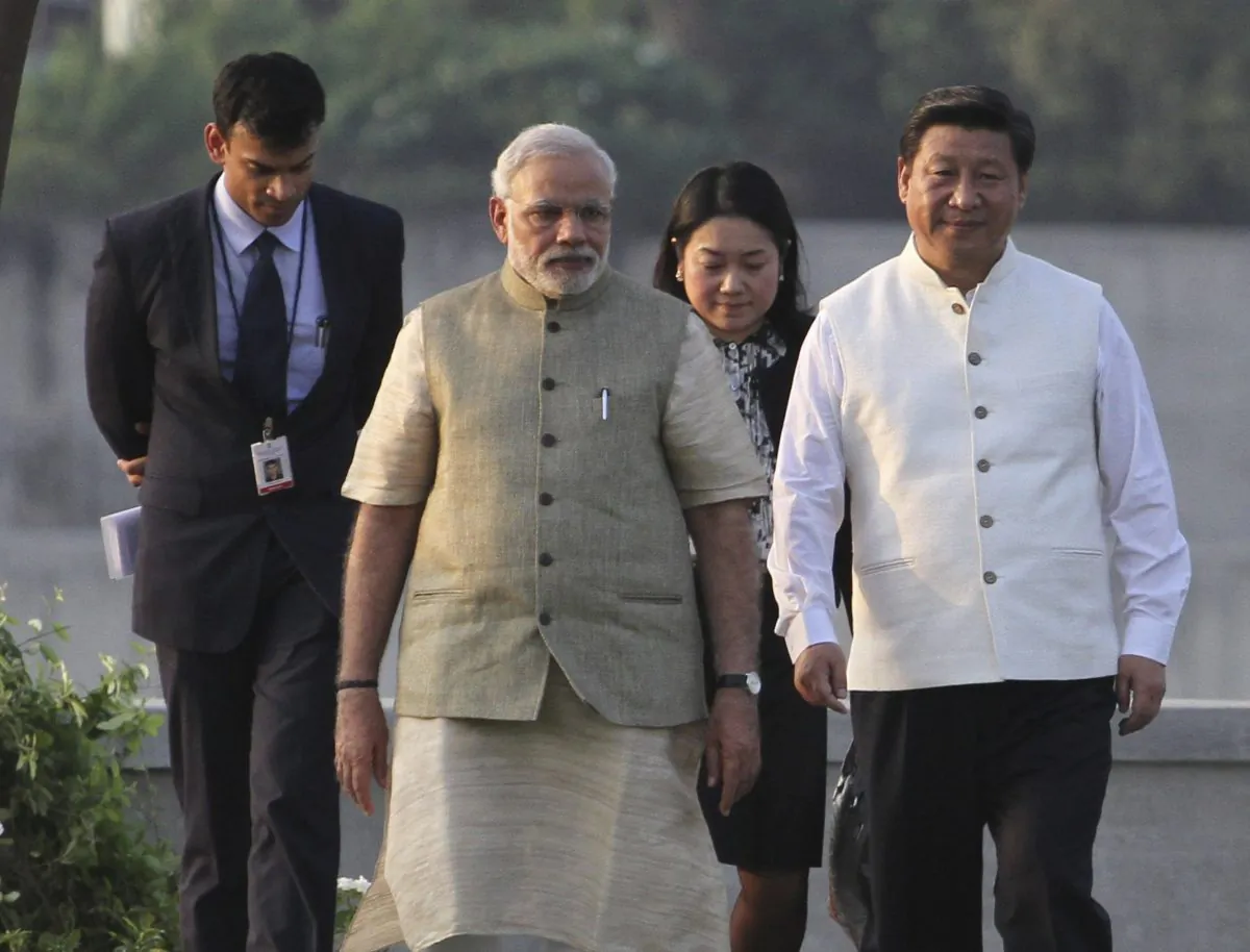 Indian Prime Minister Narendra Modi (2nd-L) and Chinese Communist Party leader Xi Jinping (R) walk on the Sabarmati River front in Ahmadabad, India, on Sept. 17, 2014. Xi is on a three day visit aimed at improving ties and investment with India. (AP Photo/Ajit Solanki)