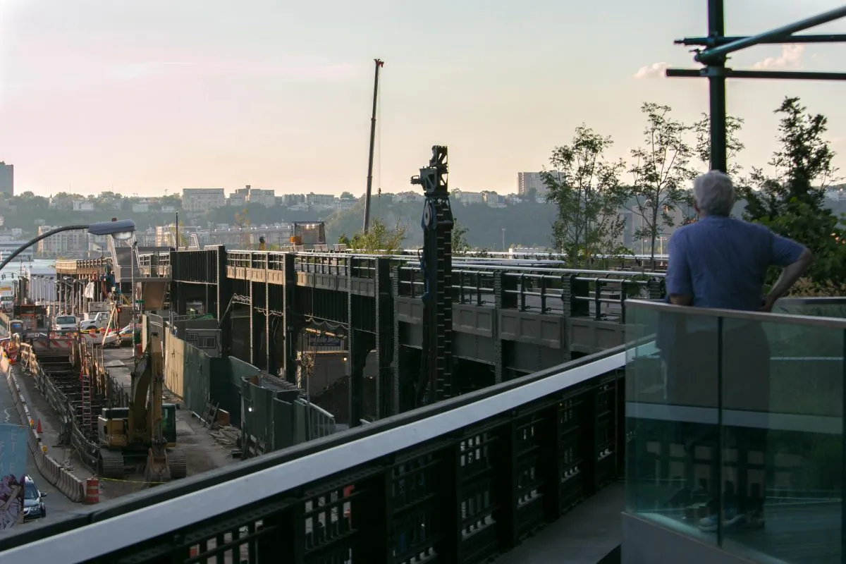 
A man looks at the northernmost part of the High Line park, the Rail Yards, in Manhattan on Sept. 18, 2014 which is still fenced off in preparation for opening on Sunday. (Benjamin Chasteen/Epoch Times) 