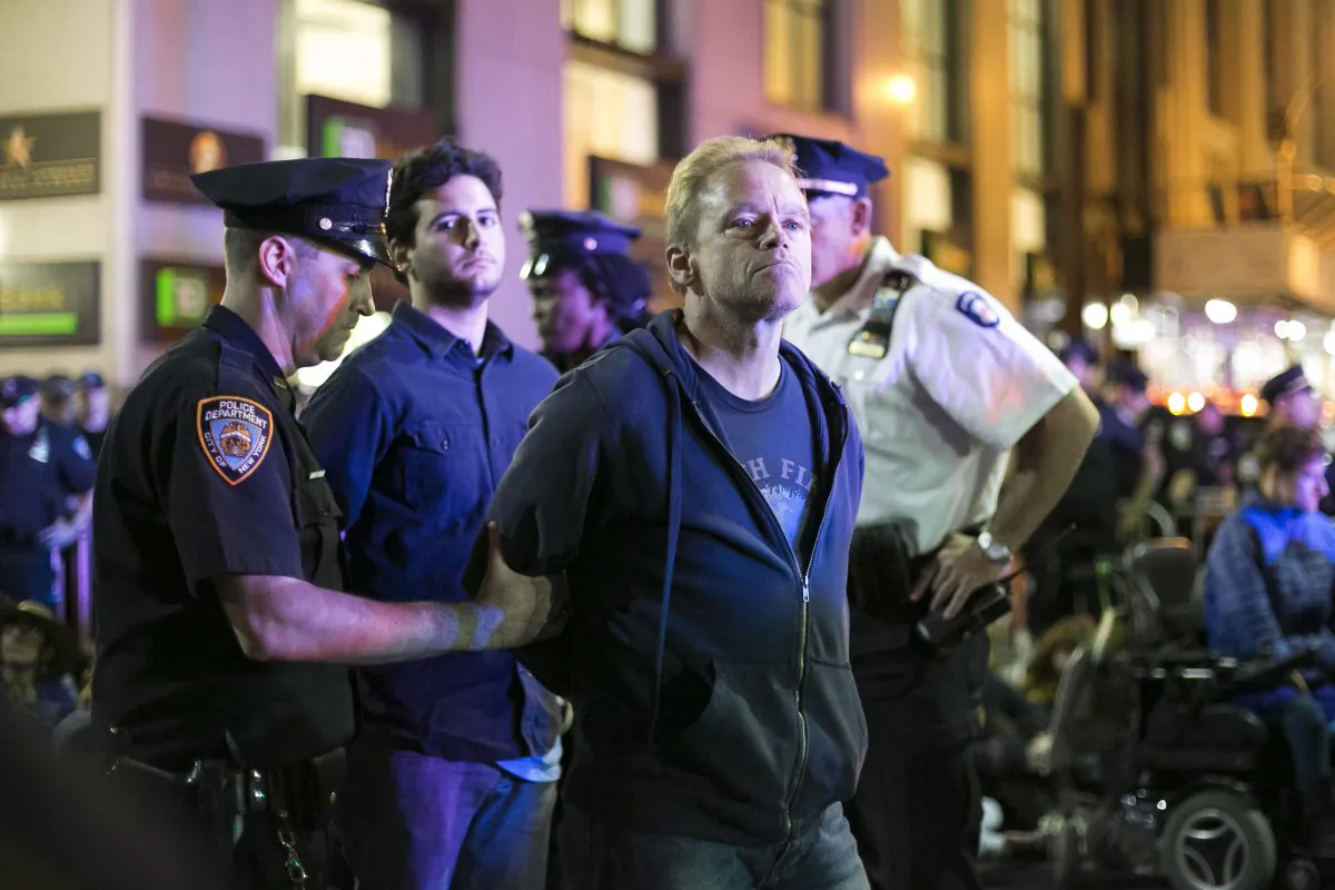 The NYPD arrests protesters during the Flood Wall Street protest at the intersection of Wall St. and Broadway in New York on Monday, Sept. 22, 2014. (Samira Bouaou/Epoch Times)