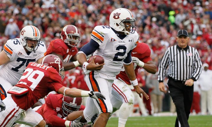 Quarterback Cam Newton (R) of Auburn rushed through Alabama defenders as the Tigers erase a 24-point deficit to beat the Crimson Tide on Nov. 26, 2010. (Kevin C. Cox/Getty Images) 