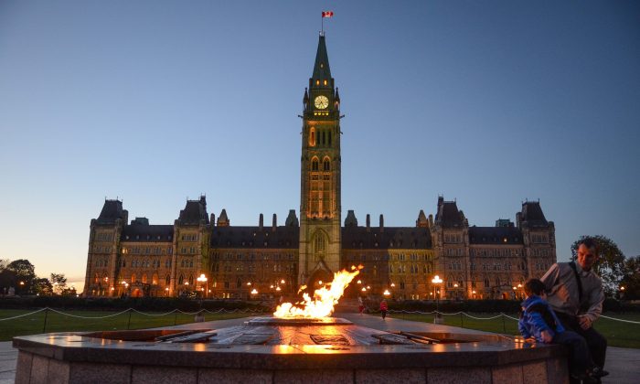 Visitors look at the Centennial Flame at Canada’s Parliament. (Matthew Little/Epoch Times)