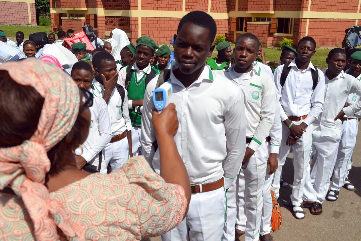 Principal of Tundunwada Secondary School Enenwan Essien checks a student's temperature in Abuja, Nigeria, on Monday. (AFP/Getty Images)