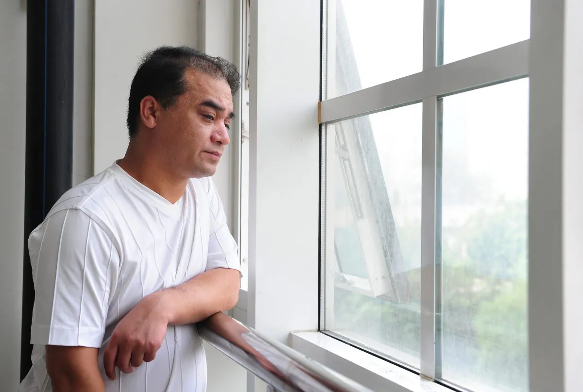 University professor, blogger, and member of the Muslim Uighur minority, Ilham Tohti pauses for a few moments for a view from the window before a classroom lecture in Beijing on June 12, 2010. Tohti, considered "China's Mandela," was recently sentenced to life in prison. (FREDERIC J. BROWN/AFP/Getty Images)